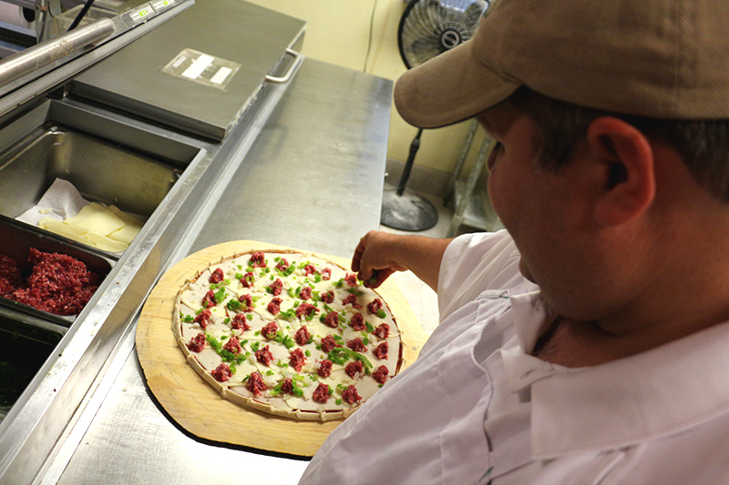 Perfecting a pizza by adding toppings